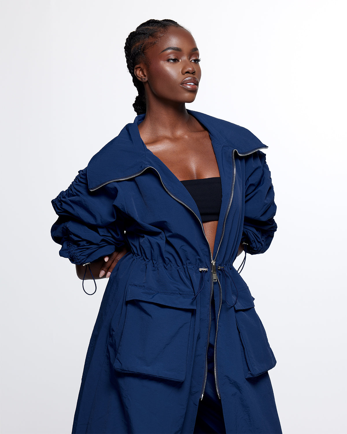 
                  
                    navy dark blue mid-length nylon trench jacket. fold over collar, two-way zip closure, bungee cinch at the waist, hem, two front pockets, two side seam pockets.
                  
                