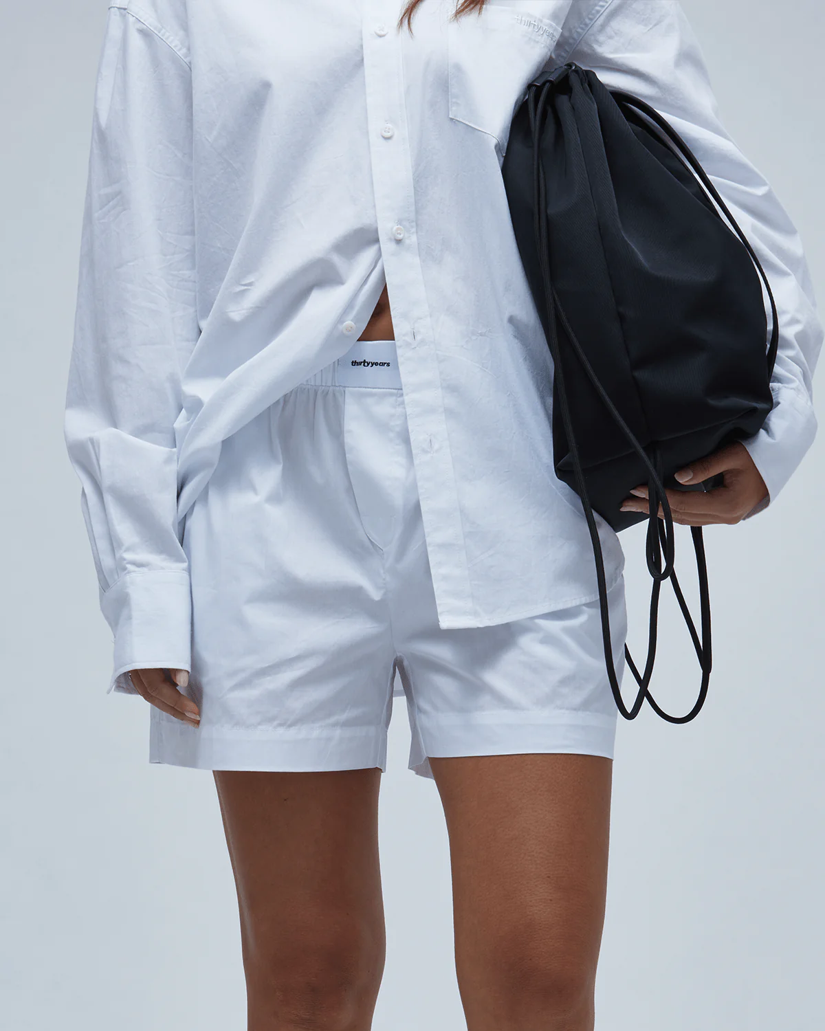Woman holding a black drawstring purse