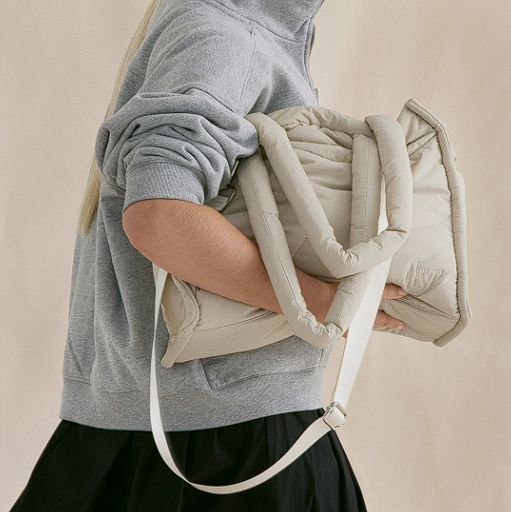 Woman holding an off-white puffer quilted bag