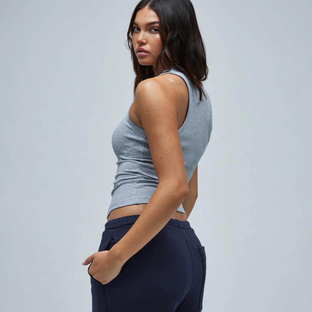 Model wearing navy pants and a gray women's basic top