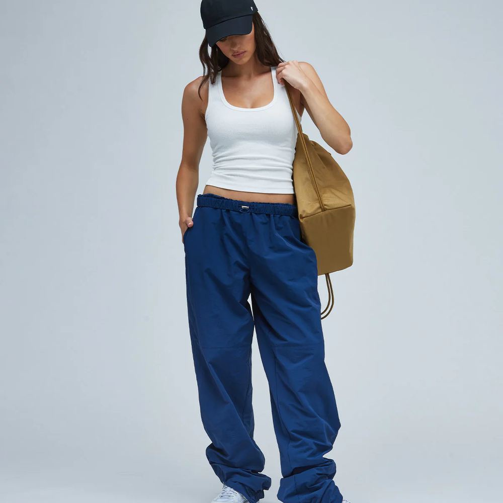 Woman wearing a white tank top and blue women's casual bottoms